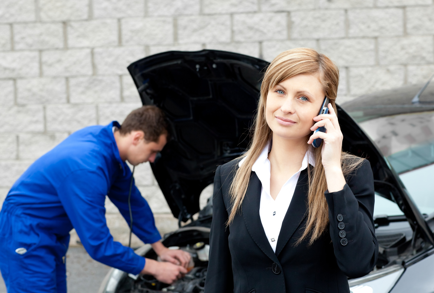 Man repairing car of business woman